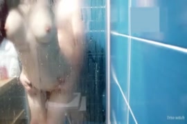 Uma miúda gira a masturbar-se e a foder no duche.